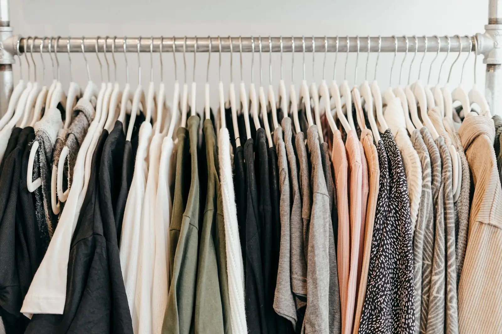 Rail of clean garments hanging in a row on hangers